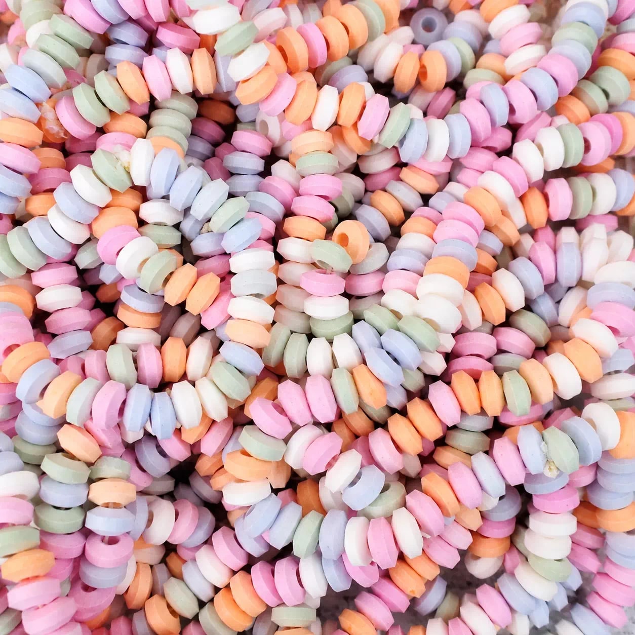 Colliers de bonbons pastel enfilés, en gros plan